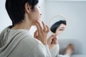 鏡を見る中年女性｜50代のお肌の悩み7選！エイジングケアってなに？