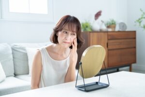 鏡で肌を気にする女性｜60代のお肌の悩み7選！若返りって可能なの？