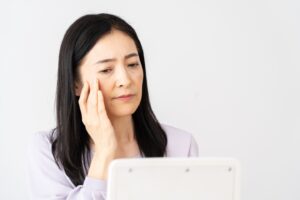 悩み顔女性｜50代の乾燥肌が改善しにくい理由｜年齢だけが原因ではない？ class=