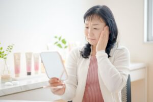 鏡を見る女性のイメージ画像01｜60代のほうれい線が深くなる理由｜対策はもう遅い？