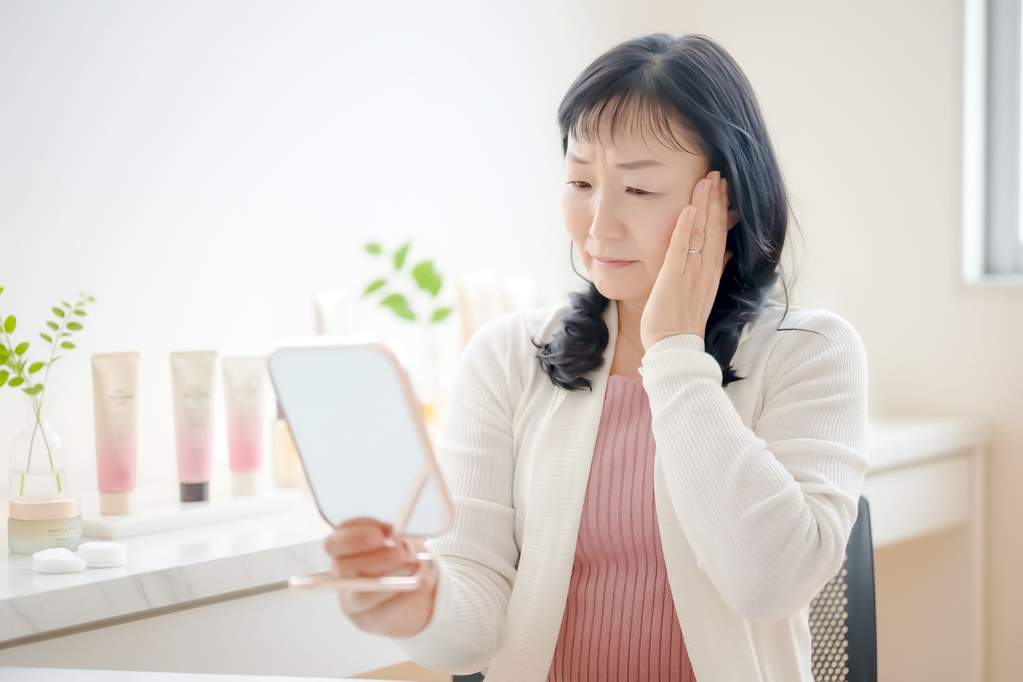 鏡を見る女性｜60代のほうれい線が深くなる理由｜対策はもう遅い？